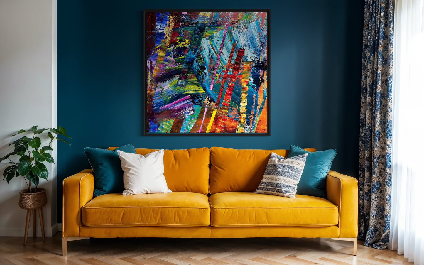 Yellow sofa with colorful cushions in a room with a blue wall and abstract painting.