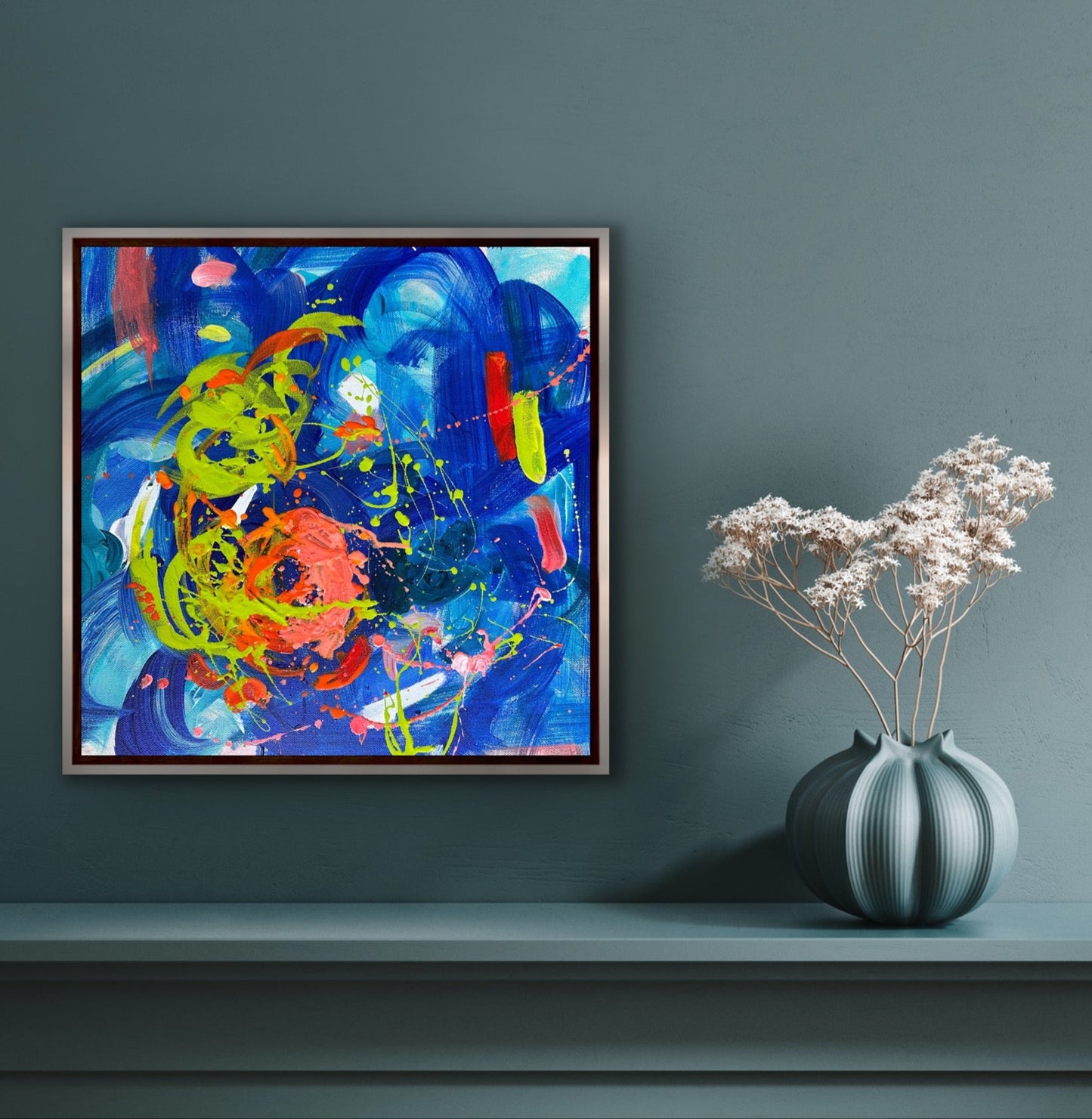 This vibrant 16” x 16” abstract acrylic painting bursts with playful energy through its dynamic blend of blues and oranges. Its lively composition invites you to explore a world of color and movement, perfect for adding a cheerful and artistic touch to any space.