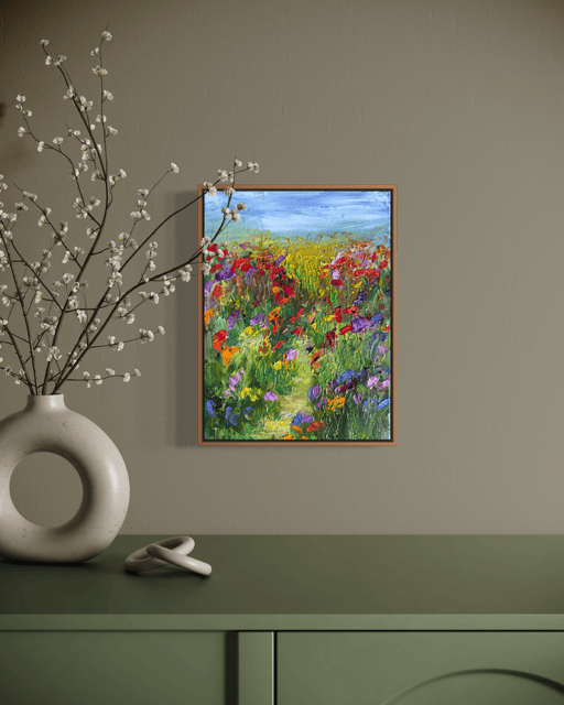 A Walk in a Flower Field painting displayed in a natural, earthy interior with a ceramic vase and green console.