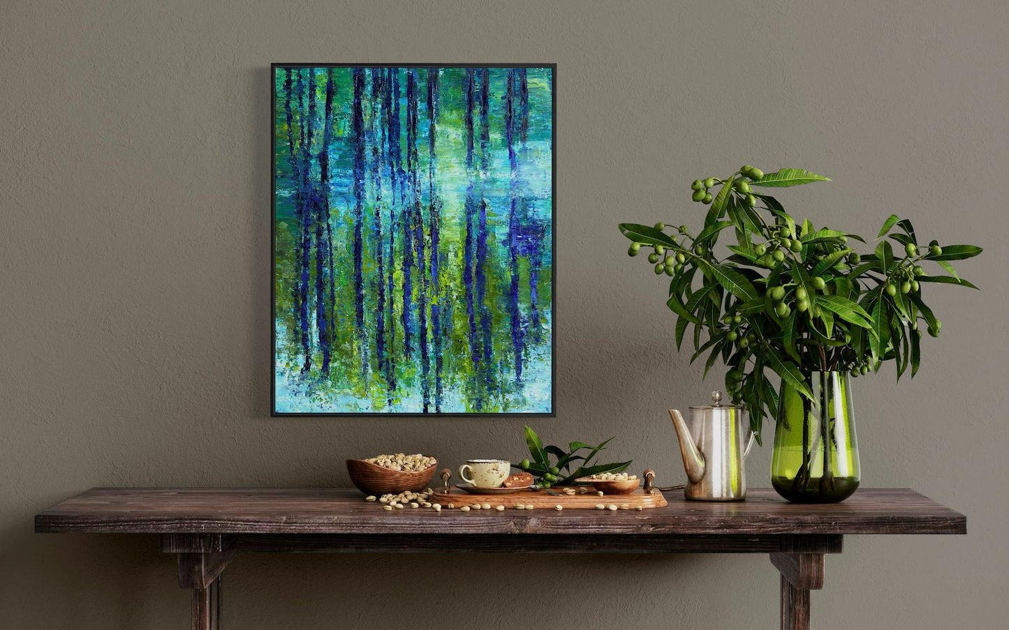 "By the Bayou" framed original oil painting by Maria-Victoria Checa hanging above a rustic wooden console table with a green plant and teapot — impressionist bayou landscape in cobalt, chartreuse, and aquamarine.