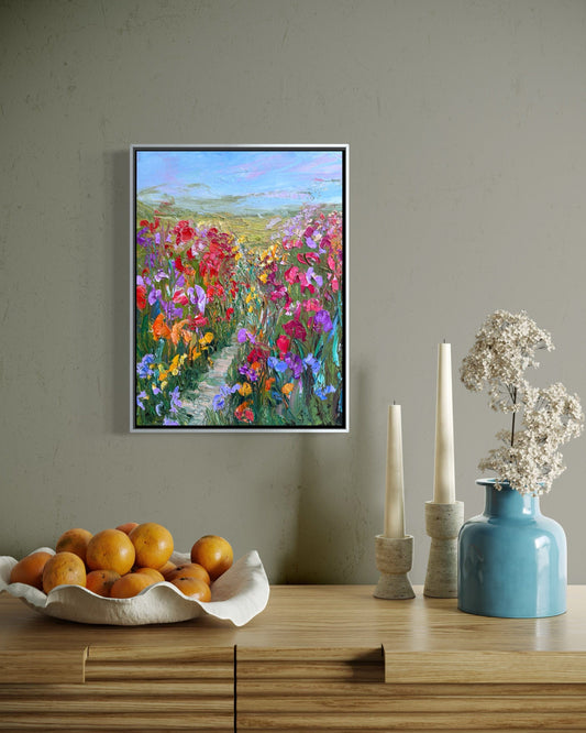 Impressionist landscape painting “Path Through Flower Field” by Maria-Victoria Checa displayed above a wooden console table in a modern interior.
