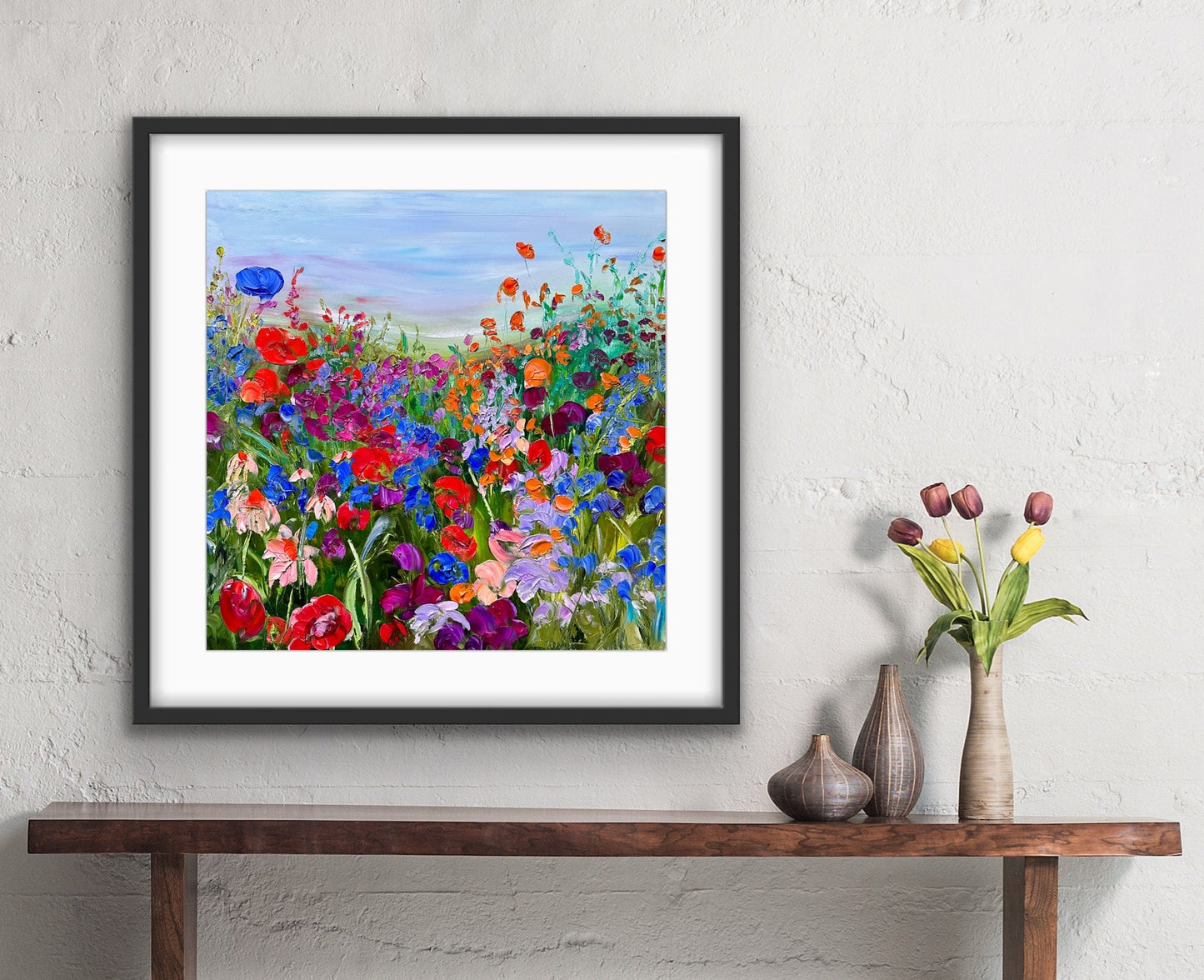 Path in the Meadow impressionist landscape painting by Maria-Victoria Checa featuring a winding path through a vibrant wildflower meadow in red, orange, yellow, purple, and pink blooms under a soft blue sky.