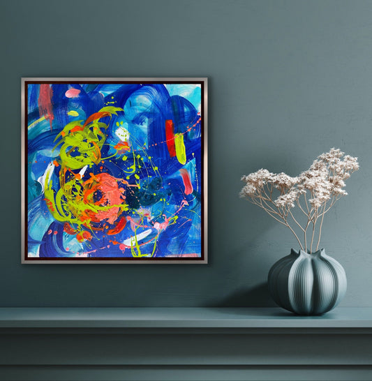 This vibrant 16” x 16” abstract acrylic painting bursts with playful energy through its dynamic blend of blues and oranges. Its lively composition invites you to explore a world of color and movement, perfect for adding a cheerful and artistic touch to any space.