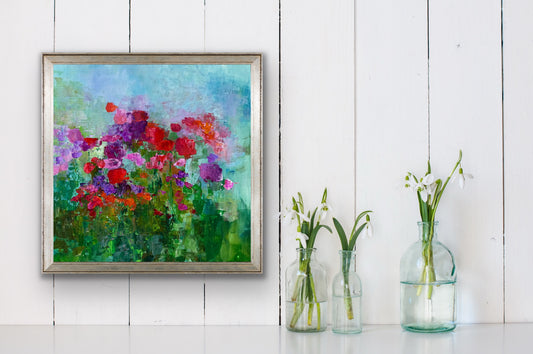 Framed floral impressionist painting by Maria-Victoria Checa against a white wall with three glass vases containing flowers below.