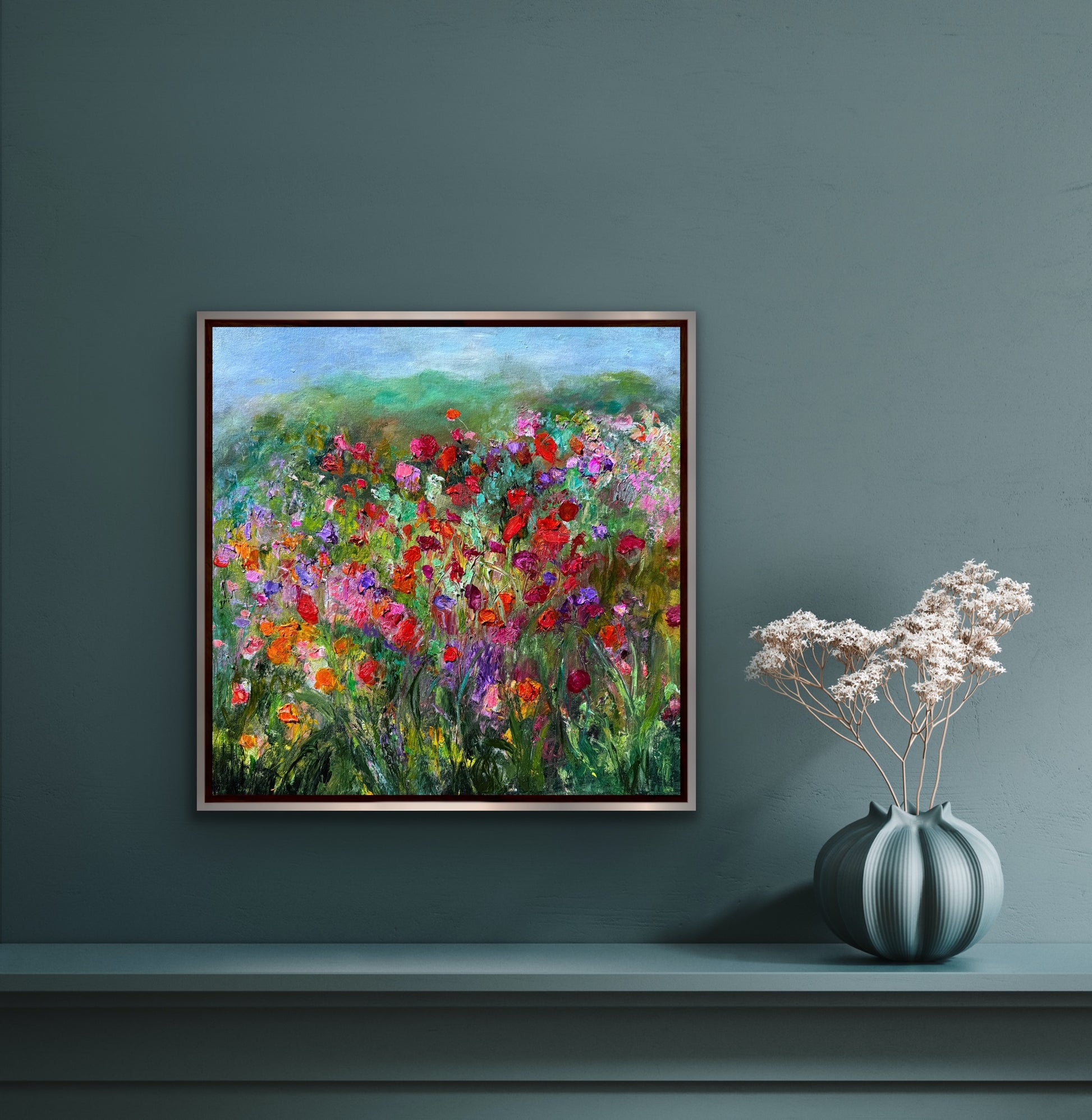 Impressionist landscape painting by Maria-Victoria Checa styled in a modern interior alongside a vase of flowers.