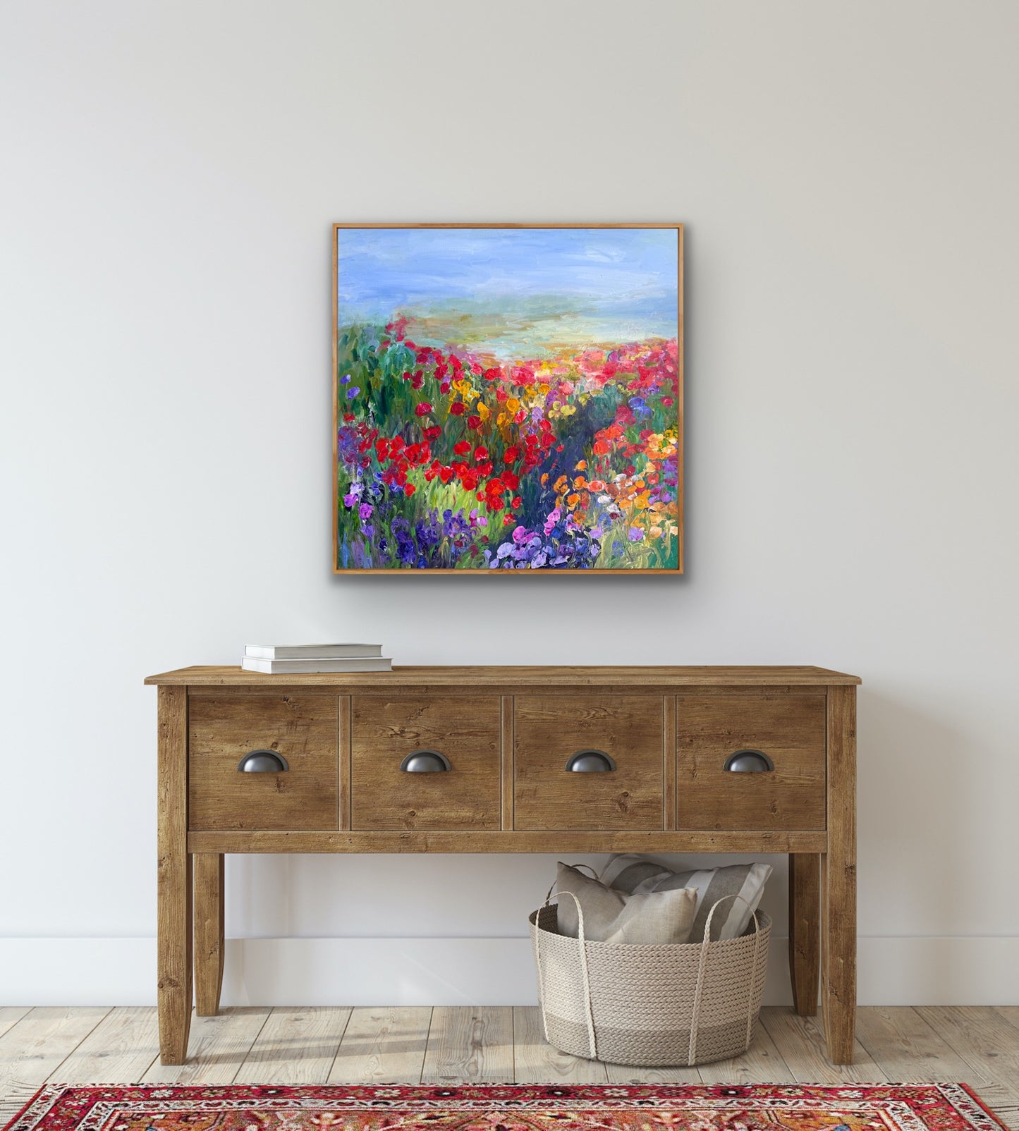 Framed impressionist landscape painting by Maria-Victoria Checa shown in a room above a side board.