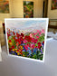 impressionist painting of red, pink and blue blooms under a soft pastel sky, by Washington DC artist Maria-Victoria Checa