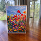 Wildflower field greeting card with vibrant red, orange, and pink poppies under a blue sky — 5x7 blank art card by Maria-Victoria Checa