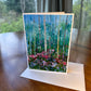 Birch forest greeting card with tall white tree trunks and pink and blue wildflowers — impressionist art card by Maria-Victoria Checa
