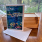 Checa Art greeting card set in clear gift box held in hand showing branded label — impressionist art cards by Washington DC artist Maria-Victoria Checa