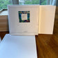 Checa Art Sunset Lilies greeting card set back of package with branded label and mvchecaart.com next to open wood gift box and envelope