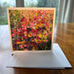 Pink and red flower garden greeting card with dense vibrant blooms in rose, crimson and golden yellow — square impressionist art card by Maria-Victoria Checa