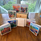 Greeting Card Set Box 5 — seven impressionist flower field and prairie landscape greeting cards displayed around a wood box, by Washington DC artist Maria-Victoria Checa