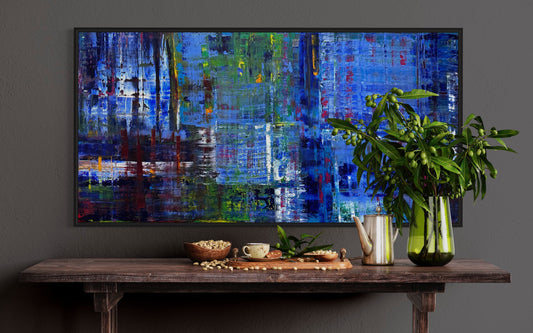 Bleu large abstract blue painting in black frame on dark wall above wood console, bold colorful art by Maria-Victoria Checa