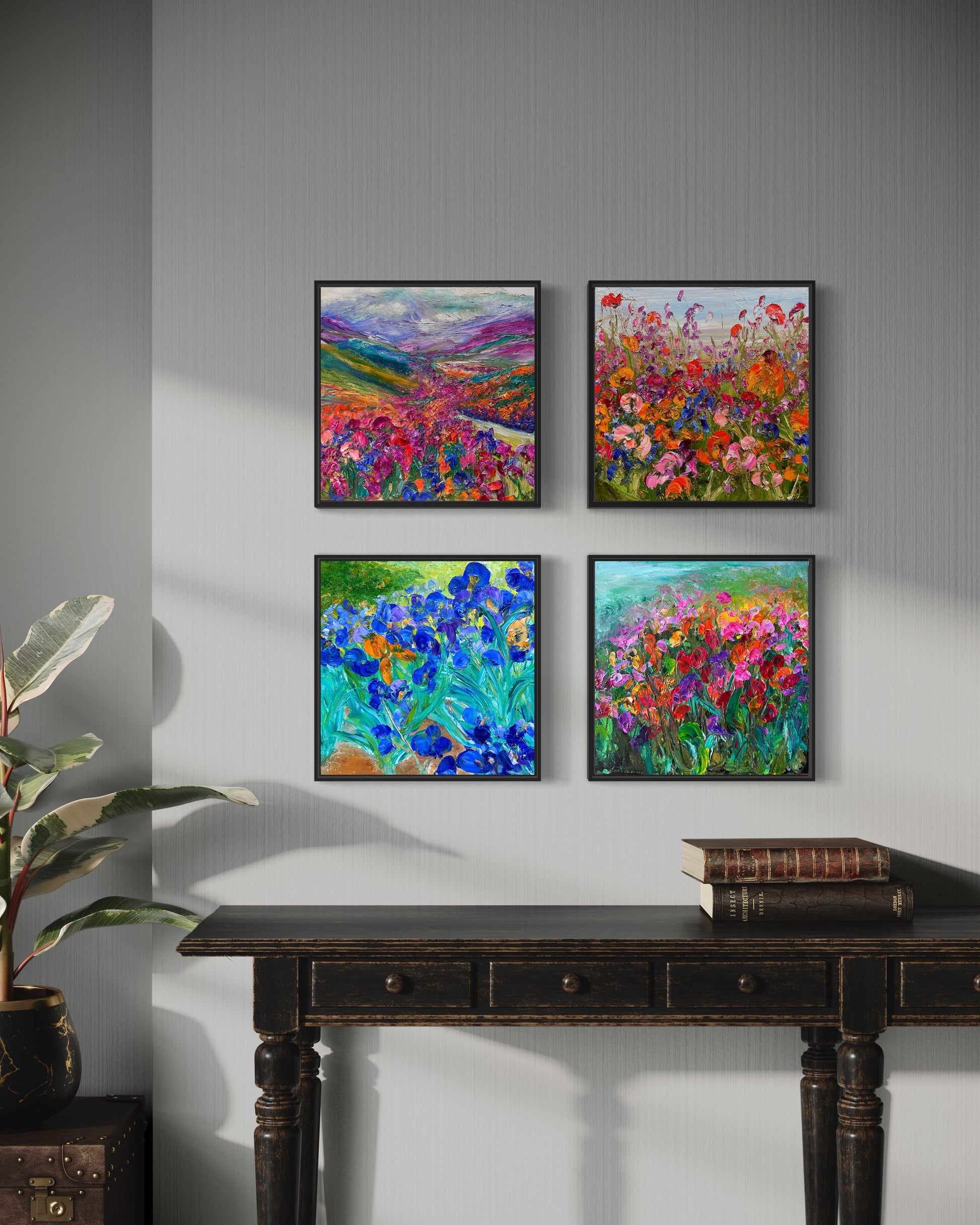 Set of four paintings of flower fields shown in a room.