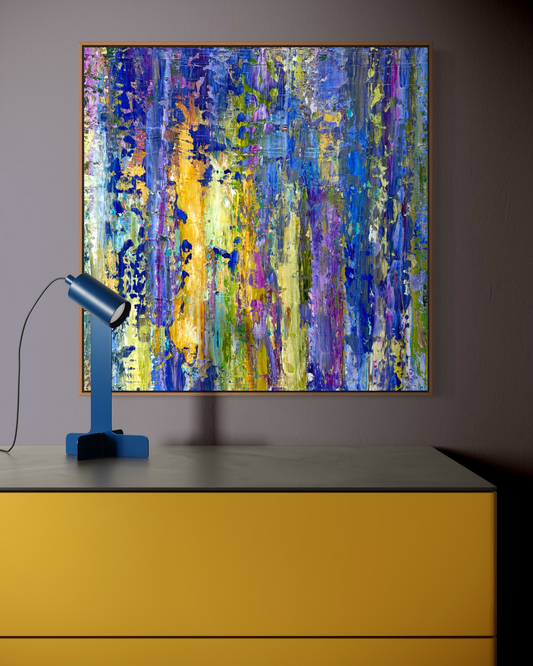 Lavender abstract painting by Washington DC artist Maria-Victoria Checa displayed above a mustard yellow console with a blue lamp, featuring layered blue, purple, and golden yellow vertical brushstrokes.