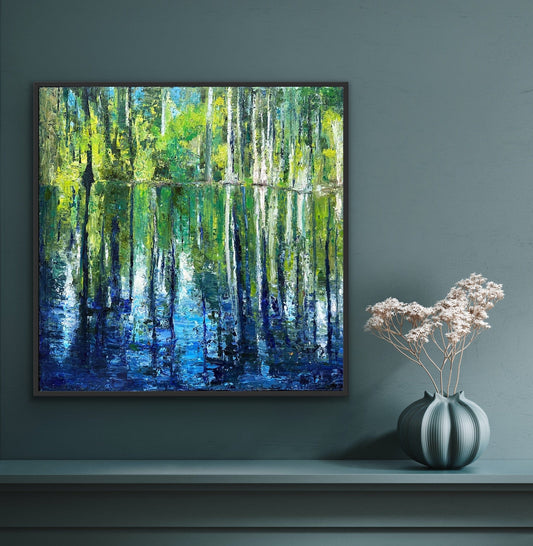 Cypress Gardens Reflection canvas print by Maria-Victoria Checa in a dark float frame displayed on a deep teal wall above a console table with a sculptural vase, showing scale in a moody modern interior