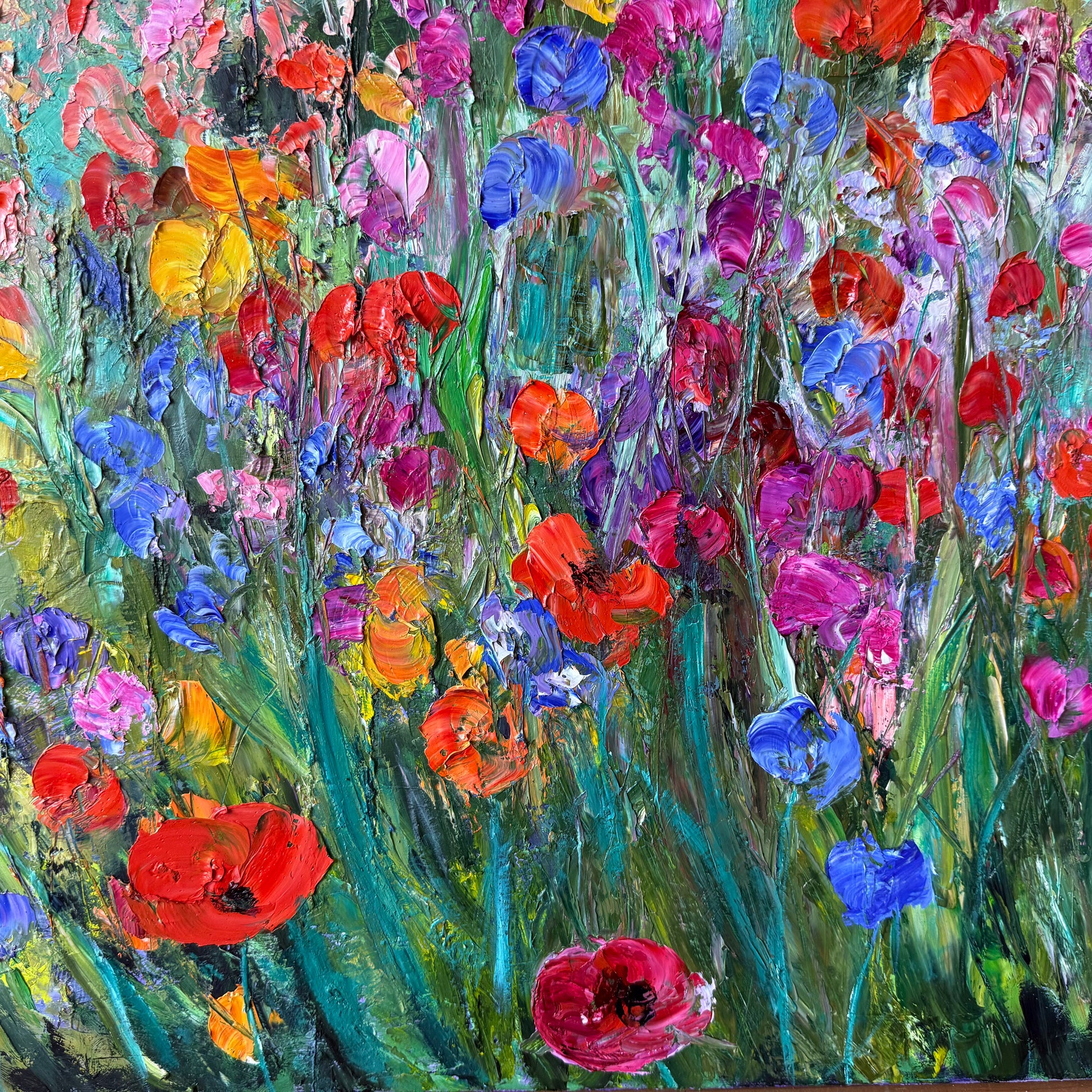 Colorful painting of flowers with red, blue, and pink hues.