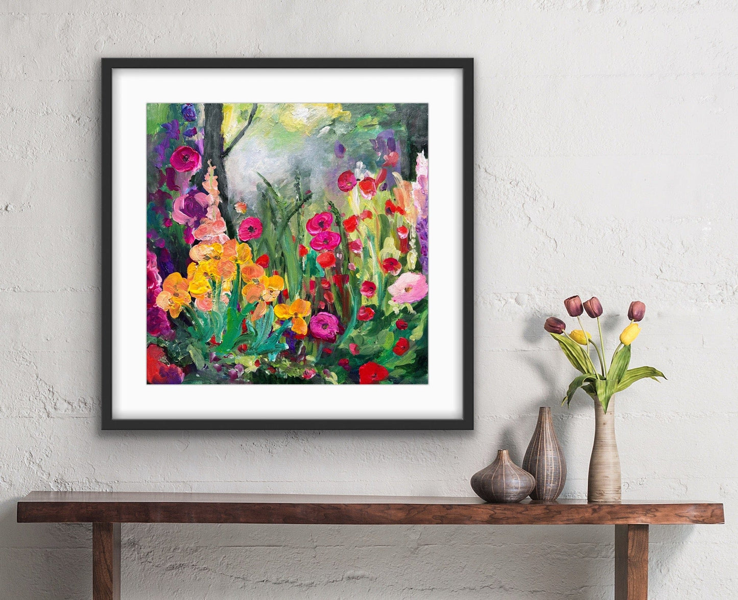 Framed Enchanting Flowers floral print with white mat displayed above a wooden console table in a contemporary home setting.