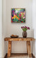 Enchanting Flowers impressionist floral print framed in natural wood above a console table with tulips, styled in a modern neutral interior.