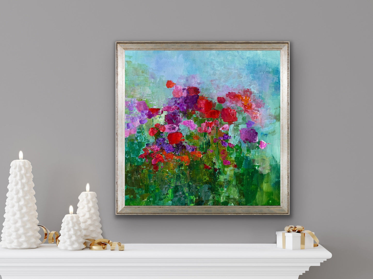 Fleeting Flowers by Maria-Victoria Checa displayed above a mantel decorated with white sculptural candles, blending colorful florals with soft neutral décor.
