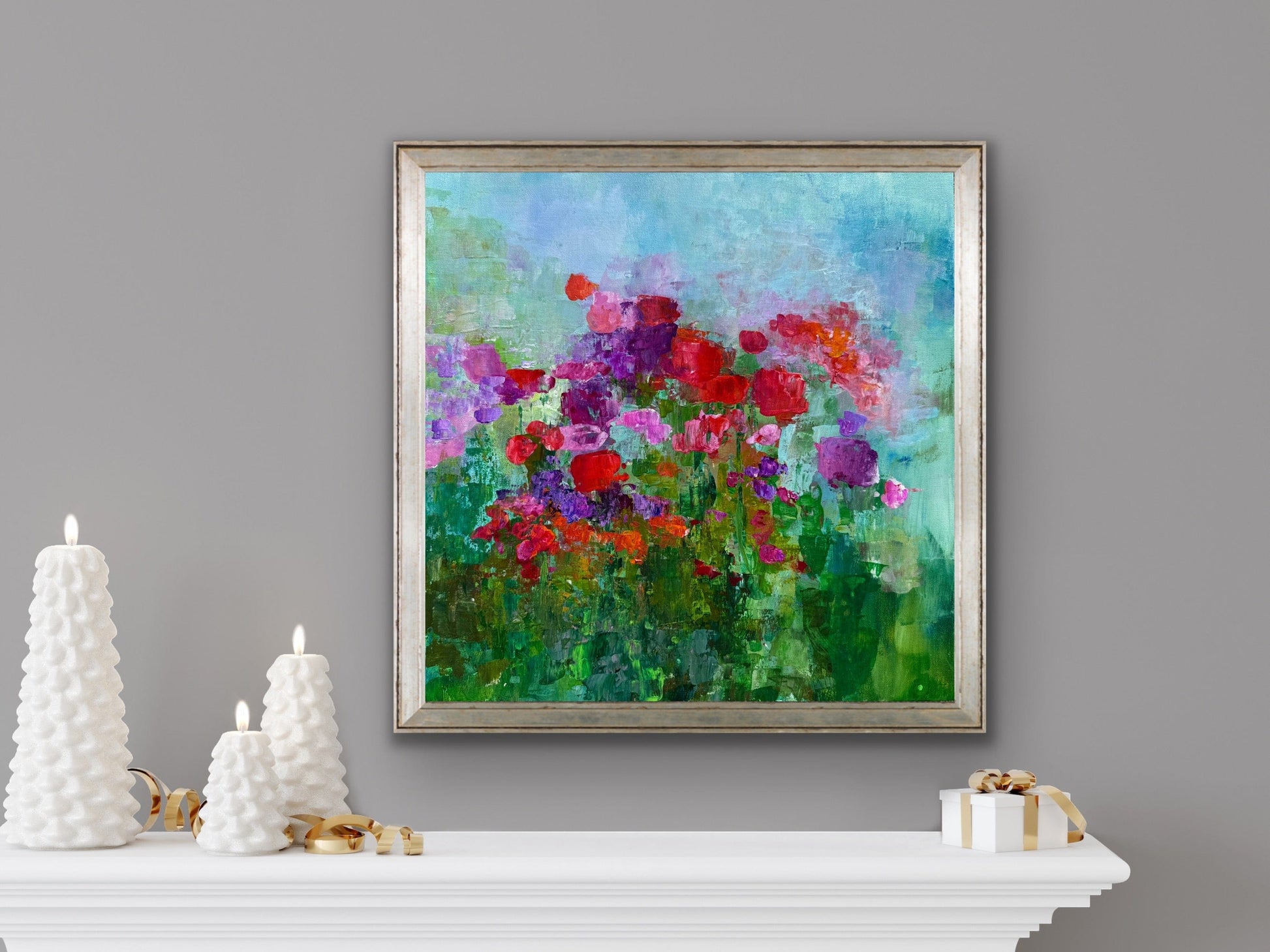 Fleeting Flowers by Maria-Victoria Checa displayed above a mantel decorated with white sculptural candles, blending colorful florals with soft neutral décor.