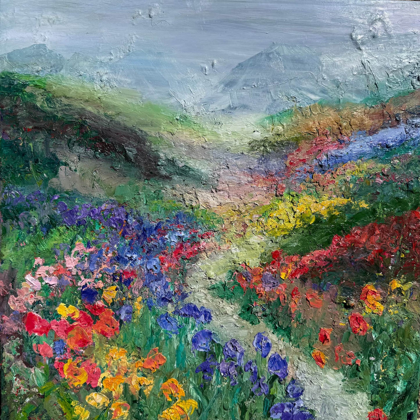 Happy Valley original impressionist landscape oil painting by Maria-Victoria Checa featuring a winding path through a vibrant wildflower valley in purple, red, yellow, and blue blooms toward misty mountains
