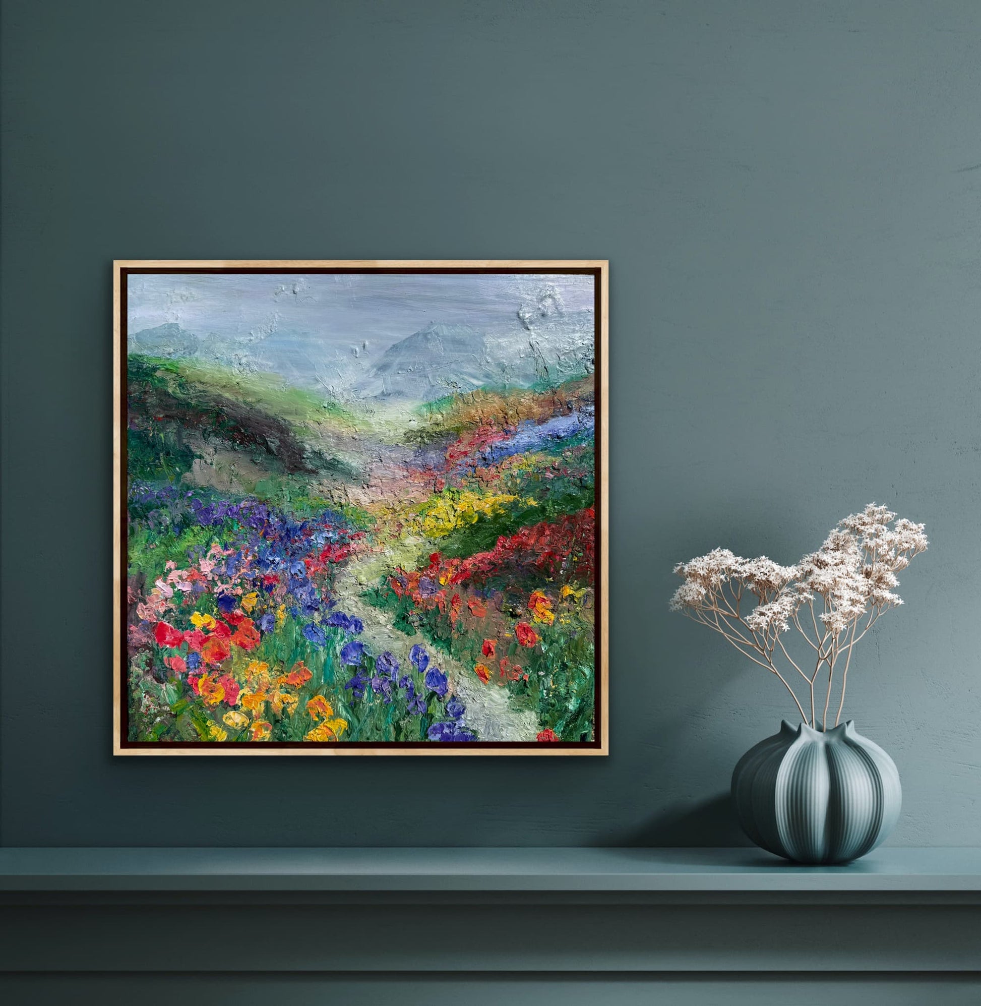 Happy Valley impressionist landscape painting by Maria-Victoria Checa in a natural wood float frame displayed on a deep teal wall above a console table in a moody modern interior