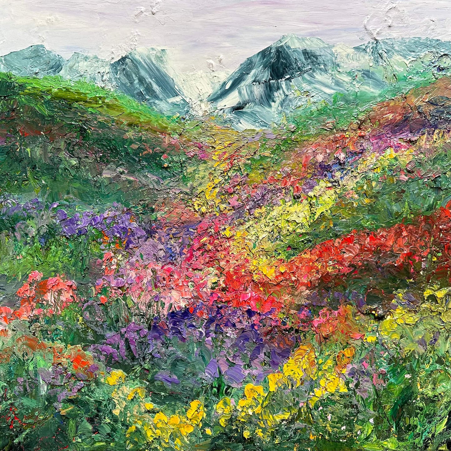 Happy Valley original impressionist painting by Maria-Victoria Checa featuring a sweeping palette knife alpine meadow in yellow, red, pink, and purple wildflowers cascading toward snow-capped mountains under a soft lavender sky.