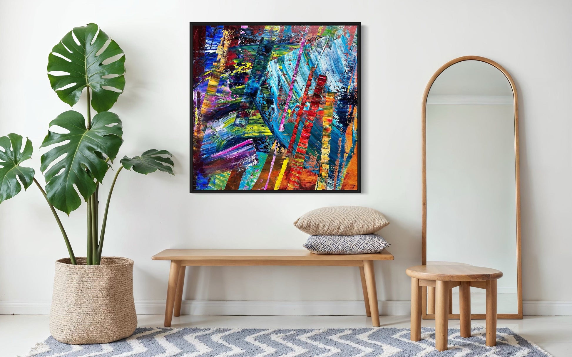 ‘It’s Wild!’ abstract painting styled in a bright entryway above a bench with a floor mirror.
