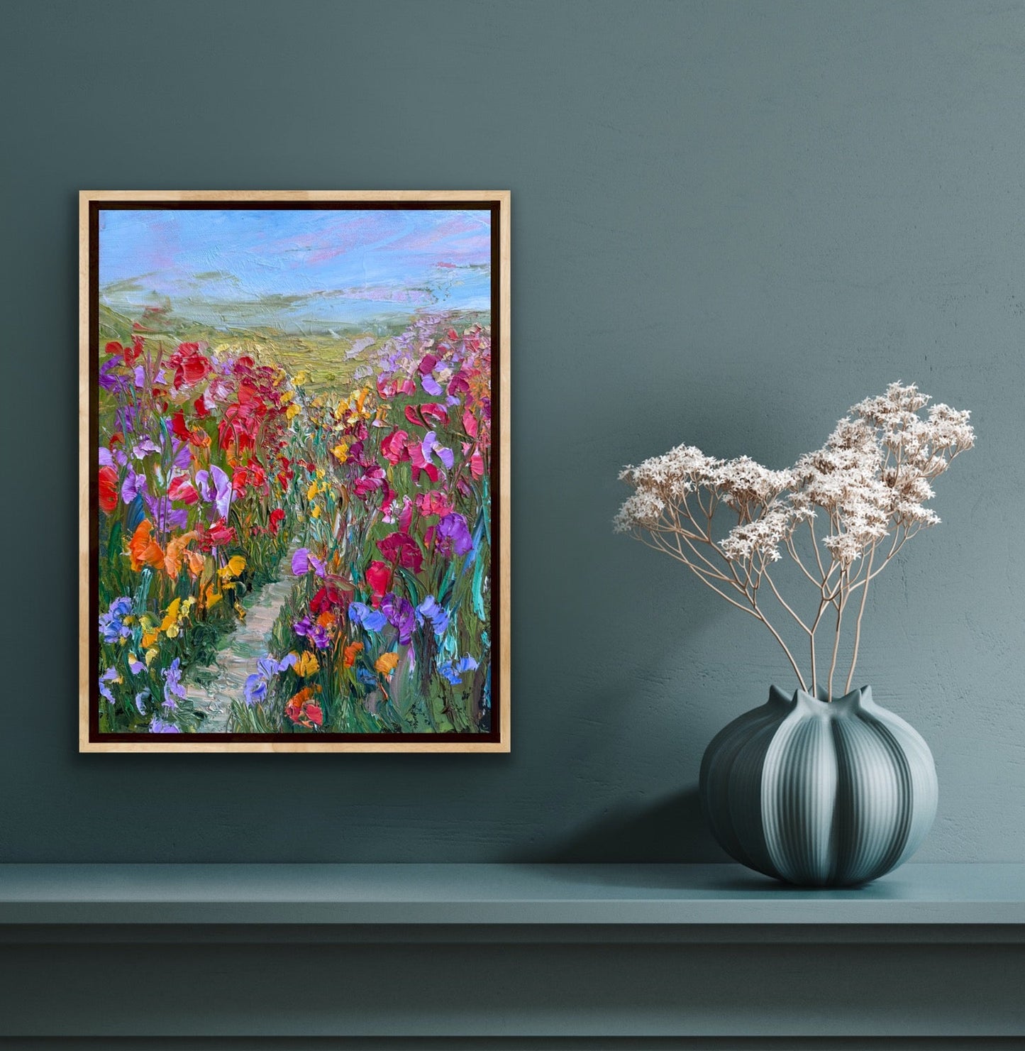 Impressionist landscape painting “Path Through Flower Field” by Maria-Victoria Checa displayed on a deep blue wall in a modern living space.