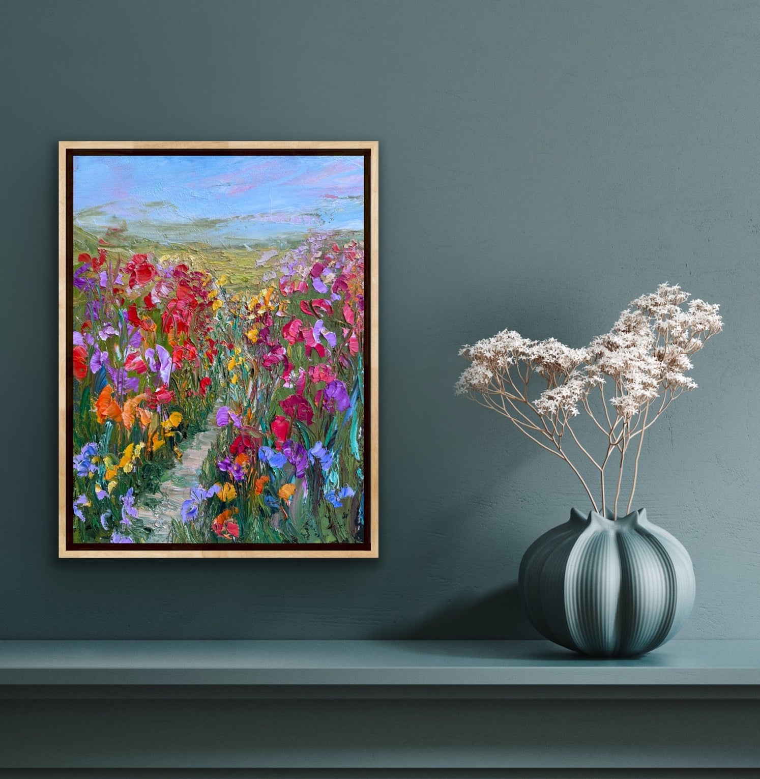 Impressionist landscape painting “Path Through Flower Field” by Maria-Victoria Checa displayed on a deep blue wall in a modern living space.
