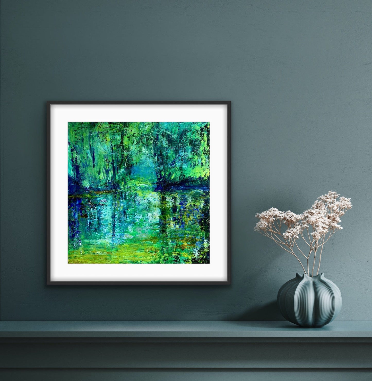 Sanctuary framed paper print with white mat by artist Maria-Victoria Checa displayed on a teal wall above a shelf with a sculptural vase.