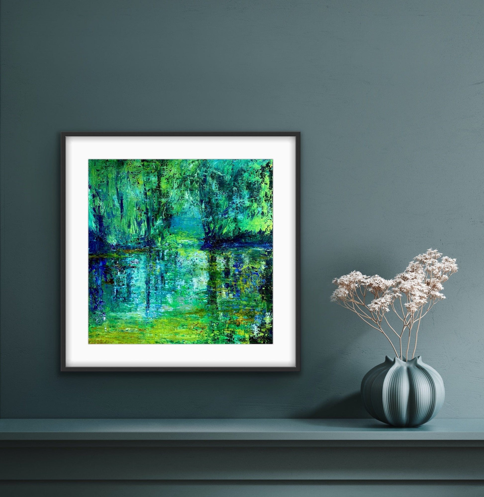 Sanctuary framed paper print with white mat by artist Maria-Victoria Checa displayed on a teal wall above a shelf with a sculptural vase.