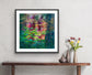 Sunset Lilies framed fine art print by Maria-Victoria Checa in a black frame with white mat, displayed above a wooden console table in a modern bohemian room setting