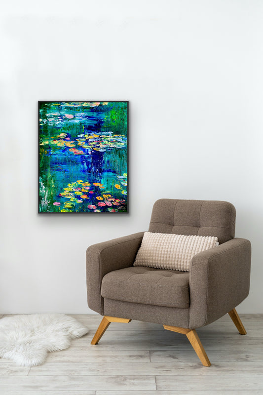 Canvas print of “Water Lily Pond” by Maria-Victoria Checa styled above an armchair, featuring bright lily pads and expressive brushstrokes in blues and greens.
