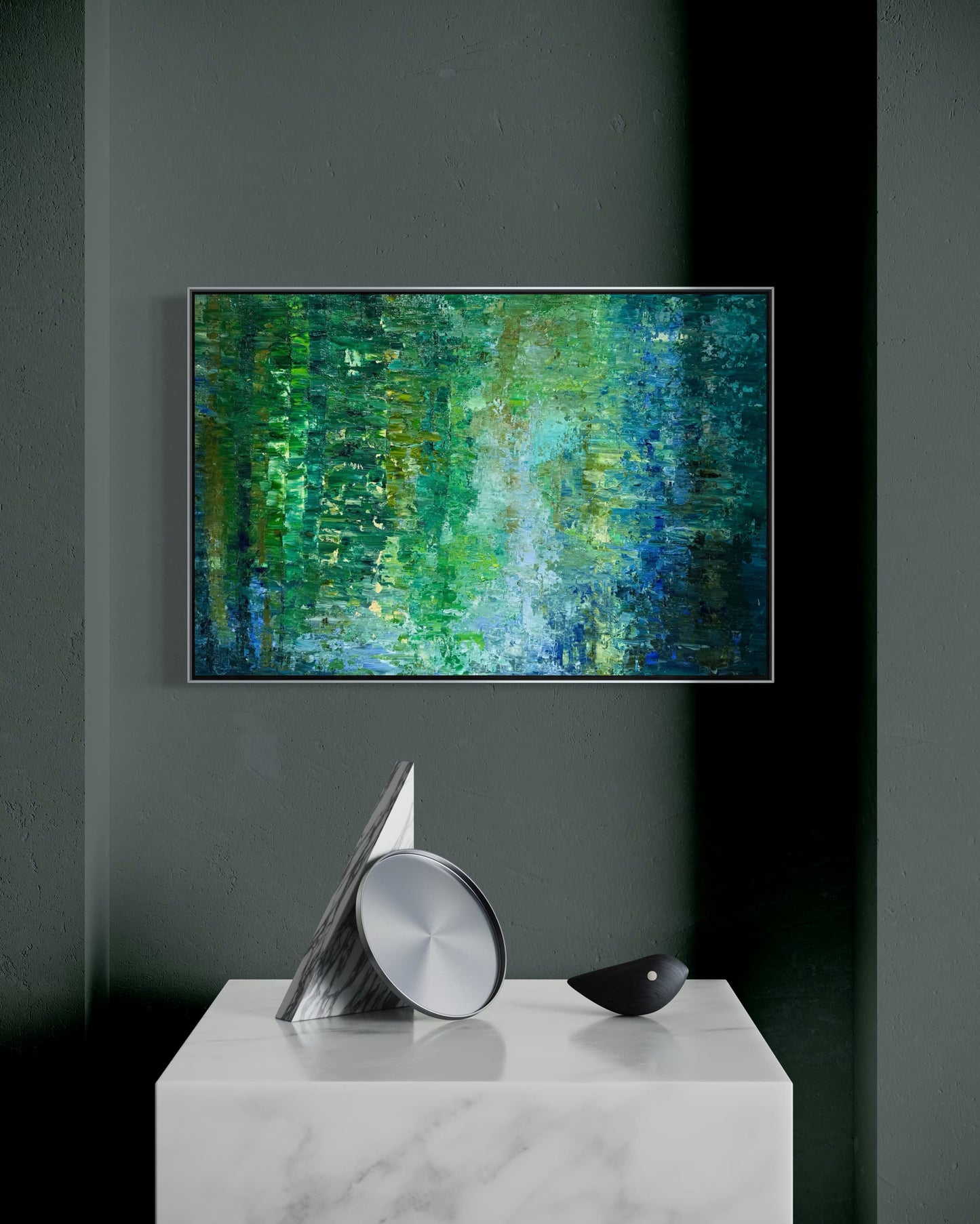 Water Reflection abstract oil painting by Maria-Victoria Checa in a silver float frame displayed on a dark green wall above a marble console with sculptural objects in a dramatic modern interior