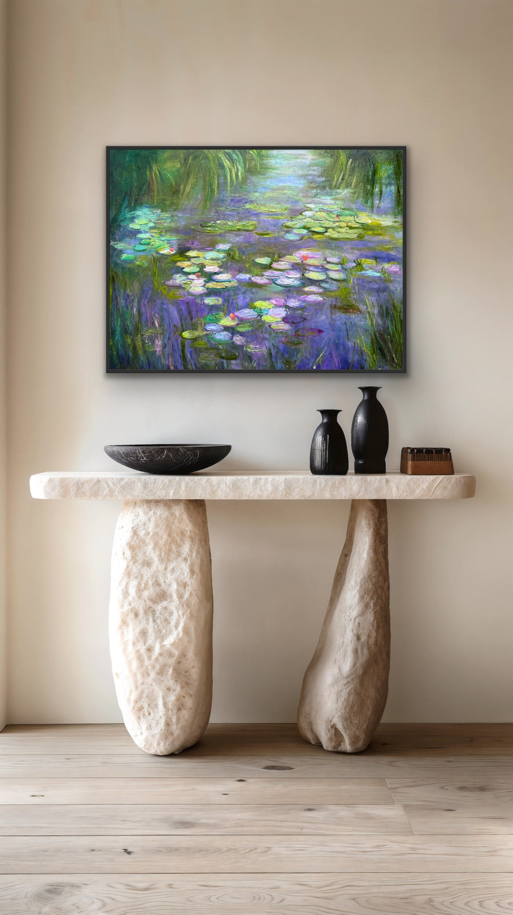Framed artwork of water lilies on a wall above a stone console table.
