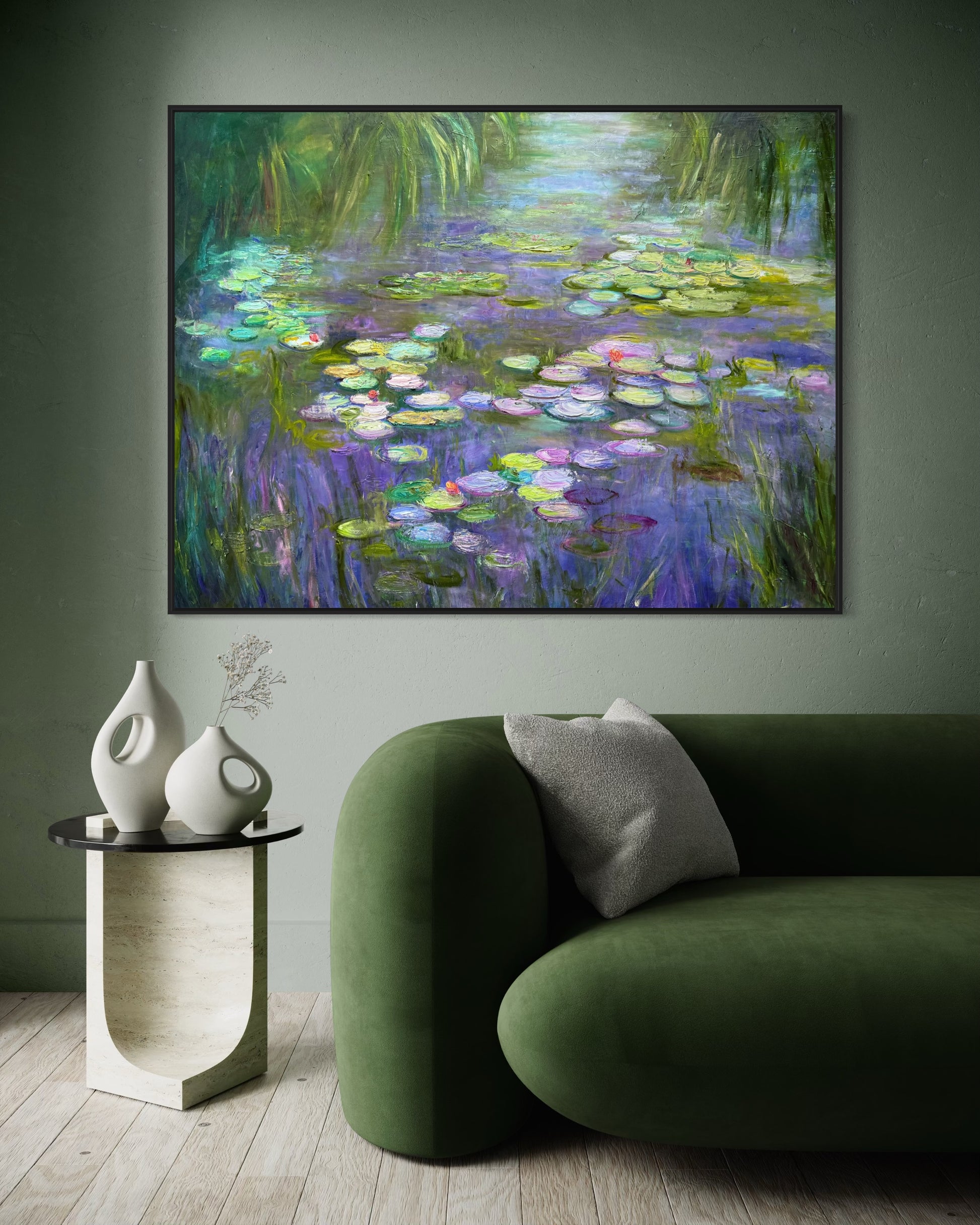 Framed painting of water lilies above a green sofa and side table in a room.