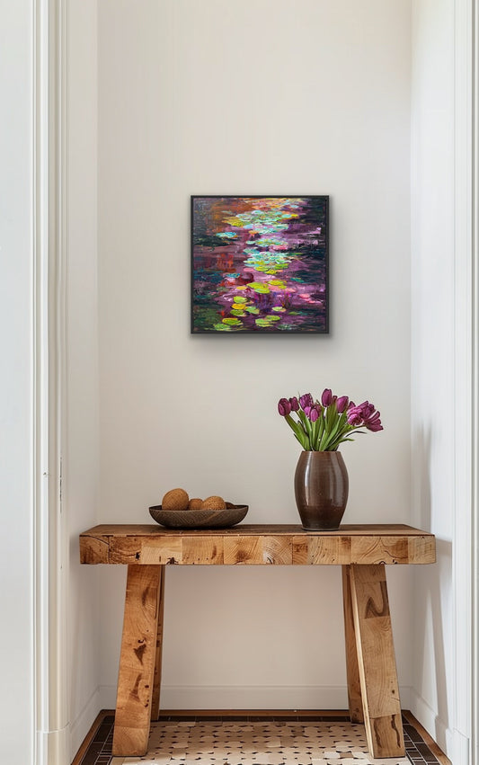 Framed impressionist landscape painting  by Maria-Victoria Checa shown above a table with vase of tulips and bowl of fruits.