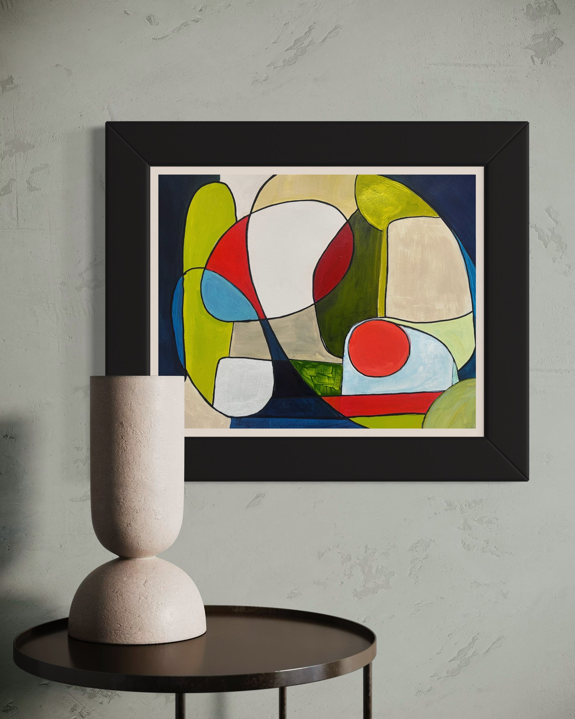 Framed abstract painting ‘You and Me’ by Maria-Victoria Checa displayed on a textured wall above a dark round table with a sculptural beige vase.