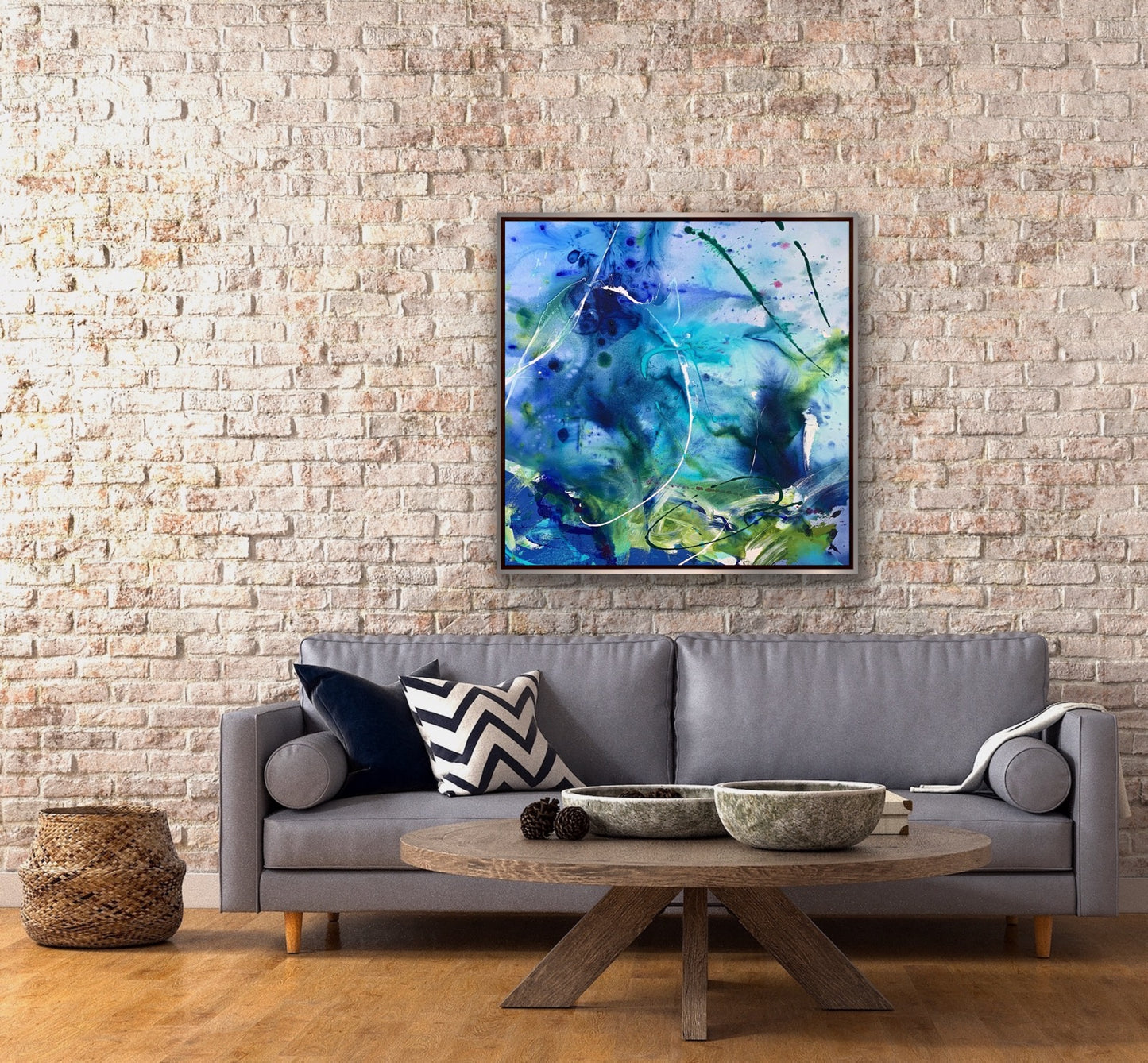 abstract acrylic painting named Chimeras in soft tones of blues in a room with a grey sofa and round table.