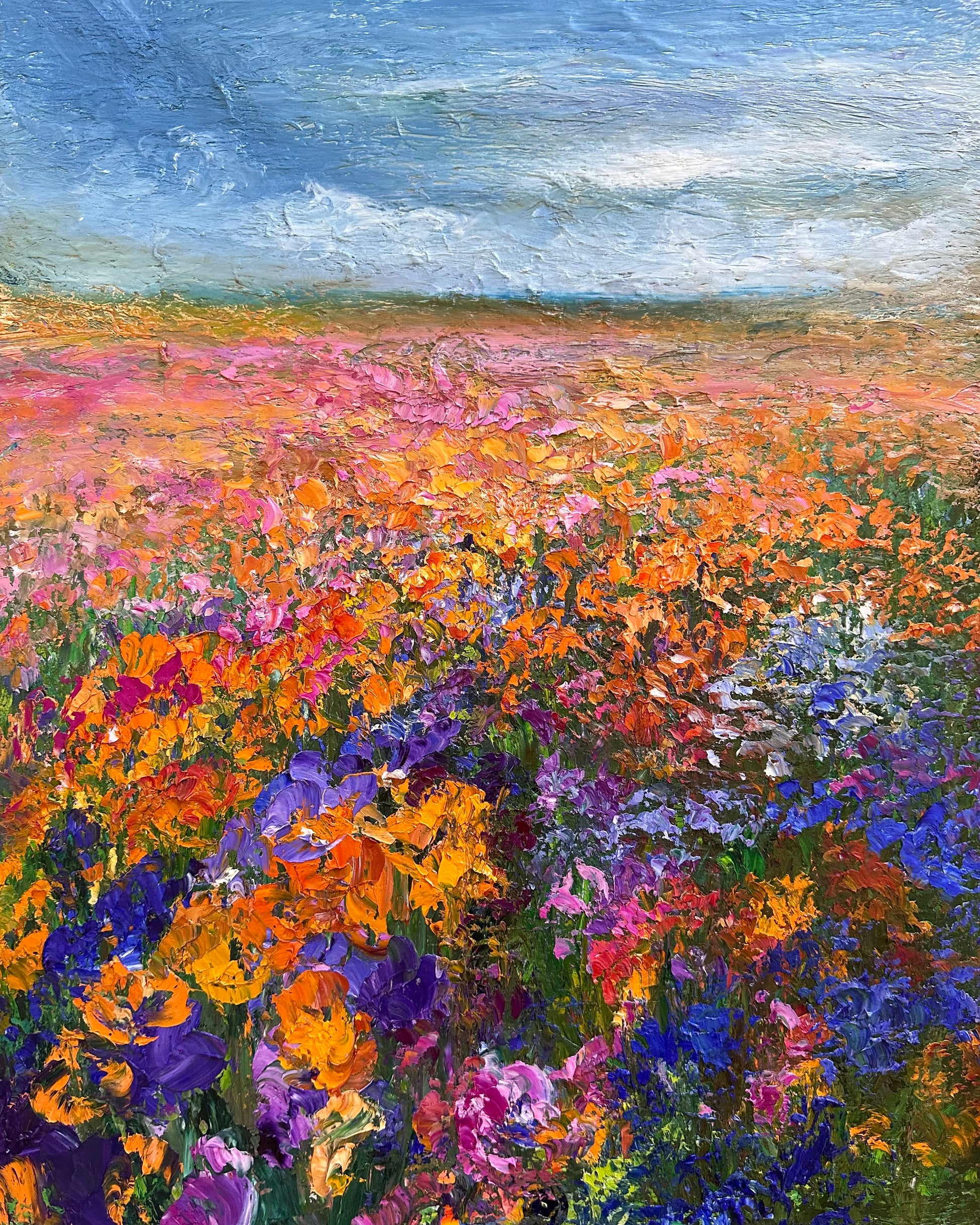 abstract oil painting of a flower field with a rainy sky with wild flowers in warm tones of oranges and pinks contrasting with blue and purple flowers.